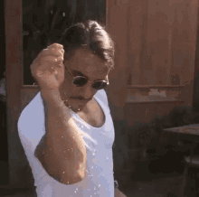 Man in sunglasses dramatically sprinkling salt from his raised hand.