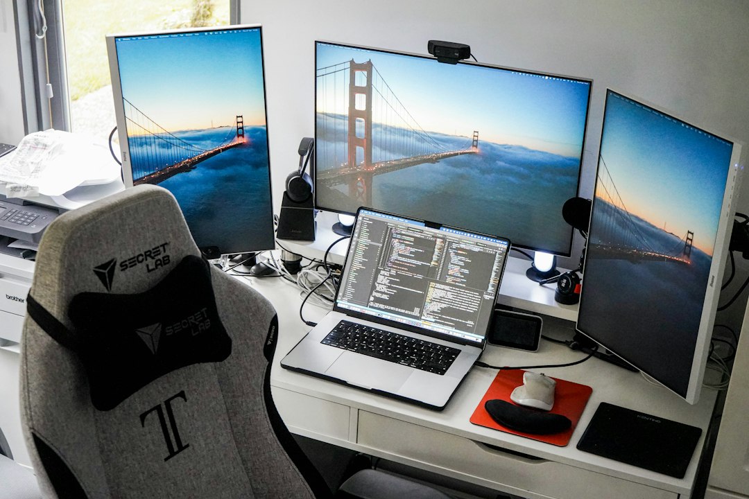 Technology workspace with a laptop and two computer monitors on a desk
