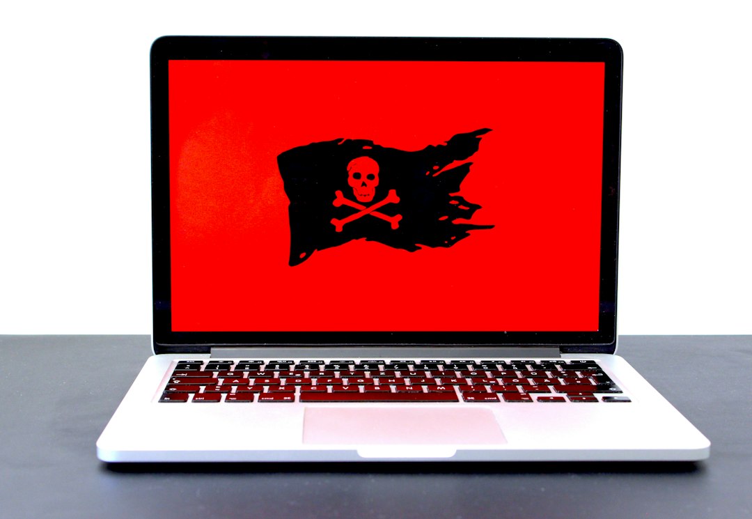 MacBook displaying a pirate flag on screen, illustrating the macOS Screen Sharing exploit.