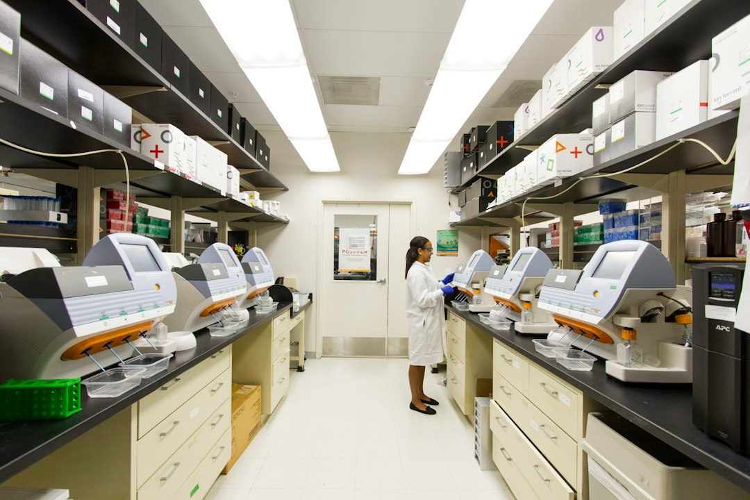 Cancer genomics technician working with sequencing equipment, illustrating mRNA melanoma Phase 3 research.