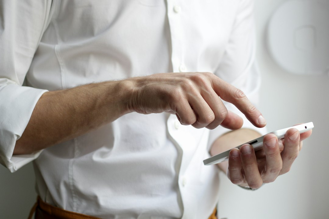 Person holding a smartphone, illustrating reporting on technology-facilitated sexual exploitation or abuse.