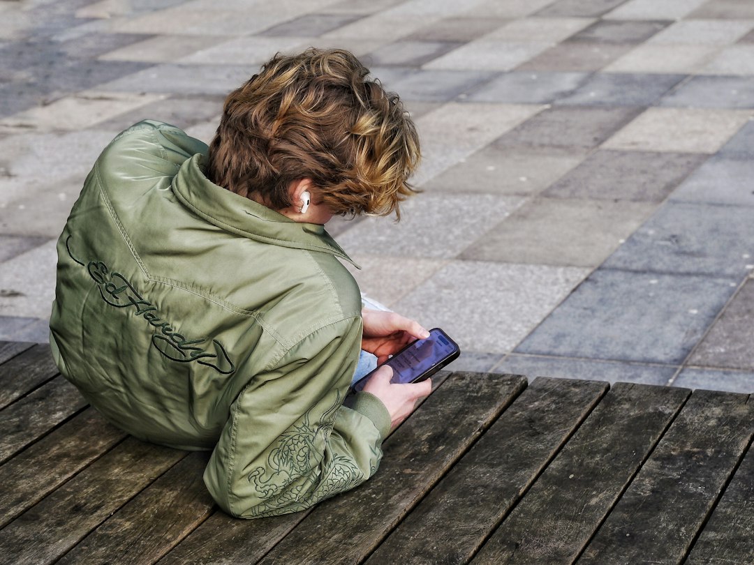 Young person using a smartphone, illustrating the EU KIDS Act.