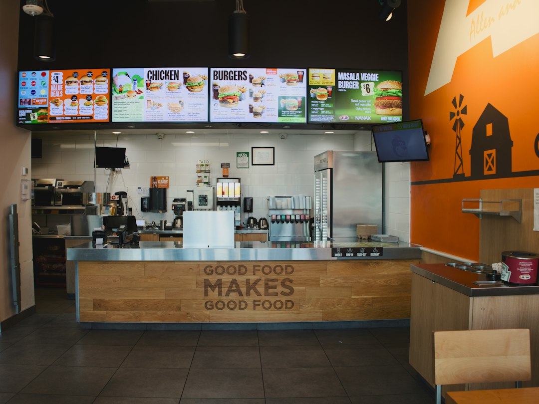 Fast-food counter with digital menu boards illustrating McDonald's AI pricing.