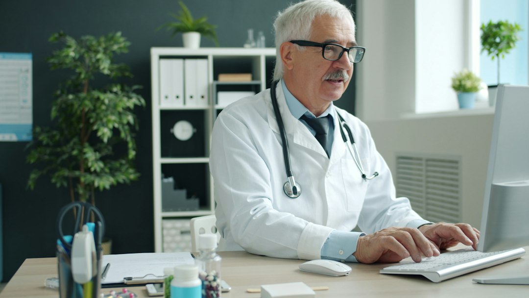 Doctor working at a computer, illustrating AI hospital billing and coding.
