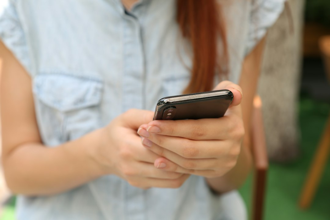 Person using a smartphone, illustrating California child safety laws for social media and AI.