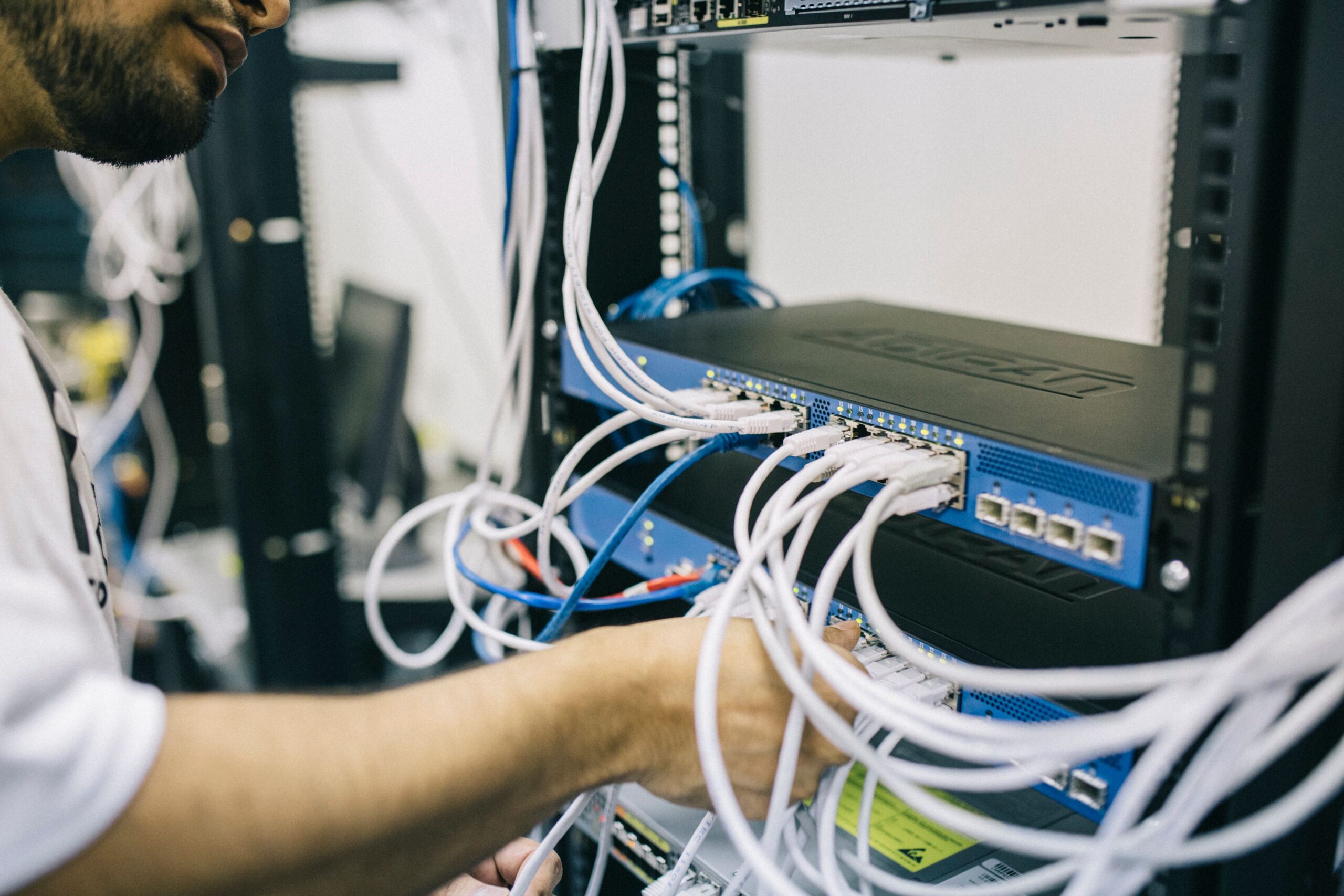 IT professional configuring network cables, illustrating Fortinet firewall security.