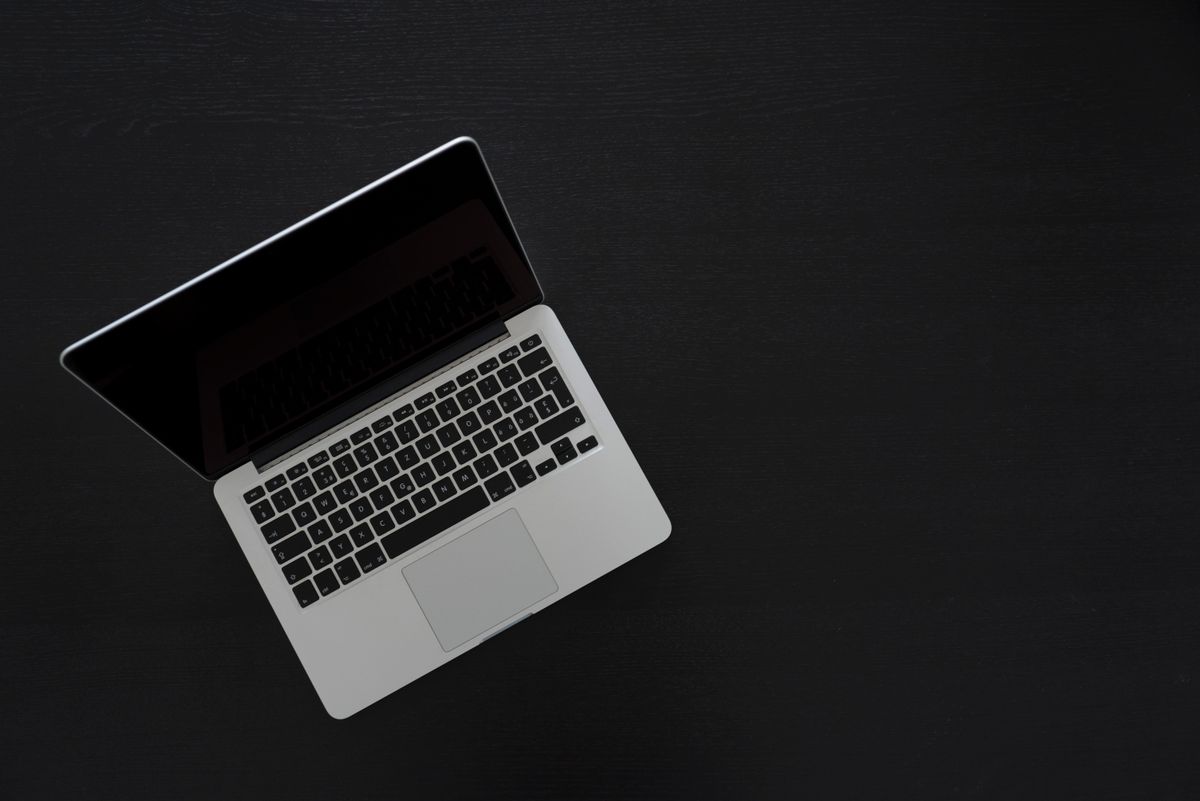 MacBook on a dark desk, illustrating macOS Full Disk Access privacy controls.