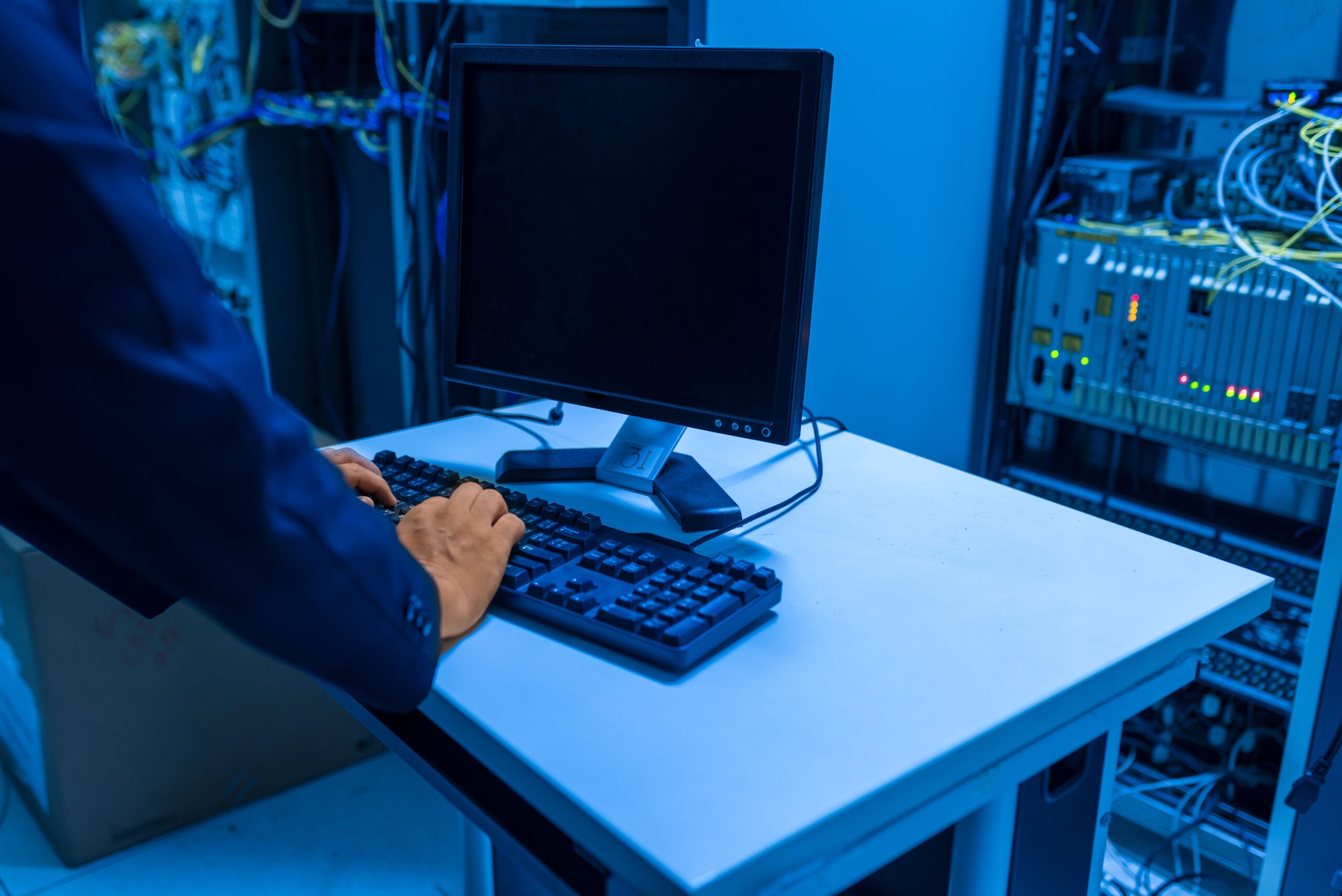 IT professional in a server room, illustrating security tools under attack.