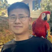 A picture of MS Therapist Fangyuan Ge with his parrot.